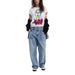 Woman wearing a white T-shirt with colorful face graphic and light blue jeans