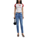 Woman wearing white T shirt with red sleeves and light blue denim jeans