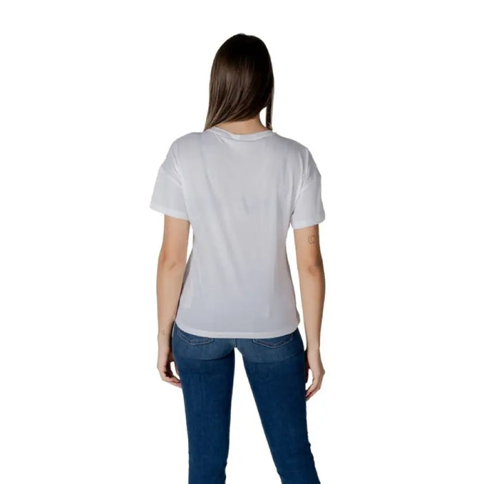 Woman wearing a white logo T-shirt and blue jeans for the Women’s White Logo T-Shirt product