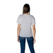 Woman wearing a white logo T-shirt and blue jeans for the Women’s White Logo T-Shirt product