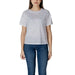 Woman wearing a white logo t-shirt and blue jeans showcasing product style