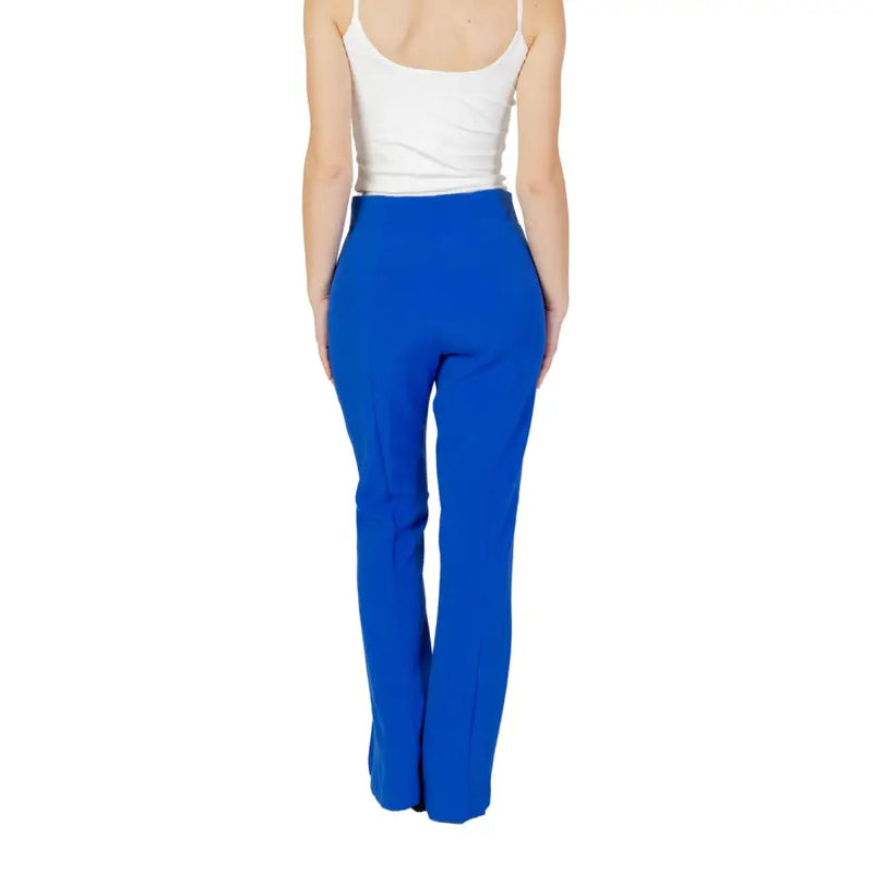Woman wearing white tank top and bright blue high-waisted trousers for spring and summer