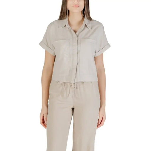 Woman wearing beige linen shirt and pants set, stylish and comfortable for women