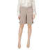 Woman wearing beige Bermuda shorts and white sneakers ensemble for casual wear