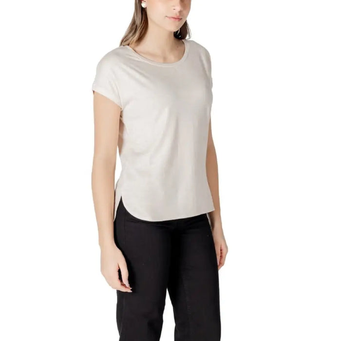 Woman wearing beige T shirt and black pants, casual fashion outfit