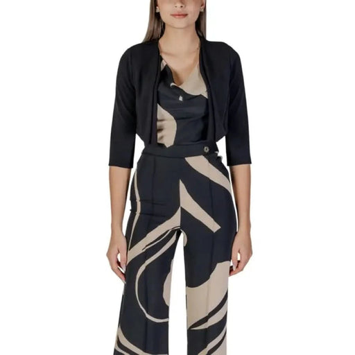 Woman’s black and beige patterned jumpsuit styled with Rinascimento long cardigan