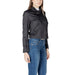Woman wearing a black biker jacket paired with blue jeans in a stylish urban setting