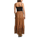 Woman wearing a black spaghetti strap tank top and a brown tiered maxi skirt