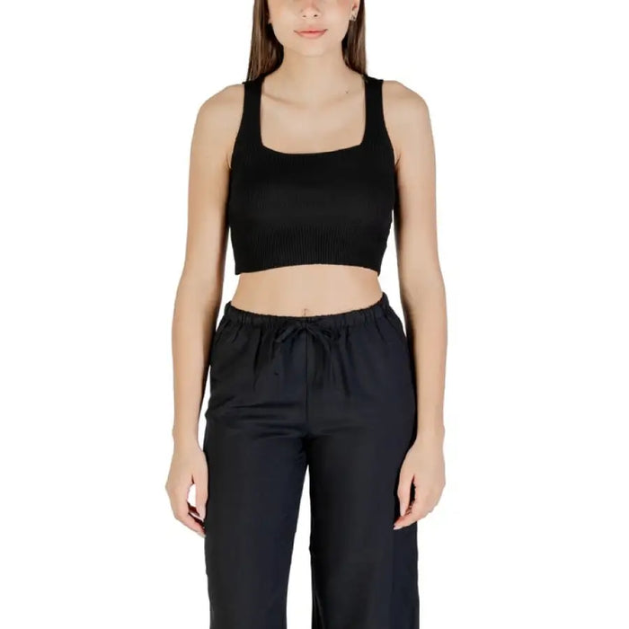 Woman wearing black crop top and pants outfit from Womens Cropped Tank Top and Black Pants collection