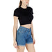 Woman wearing a black crop top and blue denim shorts, stylish summer outfit for women
