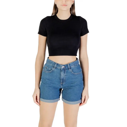 Woman wearing a black crop top and blue denim shorts displayed in Womens Black Crop Top and Blue Denim Shorts product image