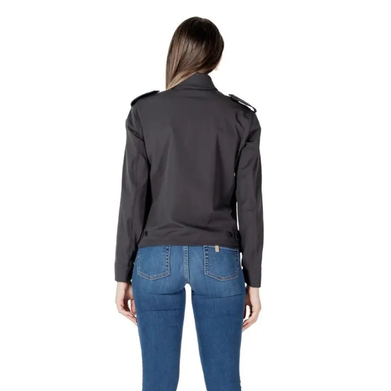Woman wearing a dark gray collared jacket and blue jeans for women