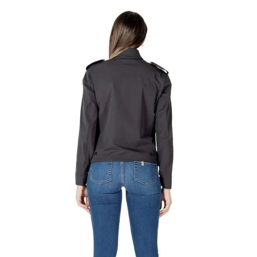 Woman wearing a dark gray collared jacket and blue jeans for women