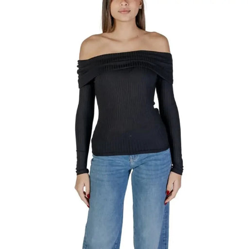 Woman wearing Jacqueline De Yong black knit boat neck sweater with blue jeans