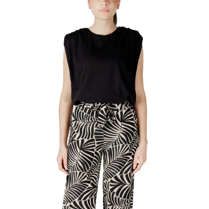 Woman wearing a black top and patterned pants from White Crop Top and Blue Pants for Women collection