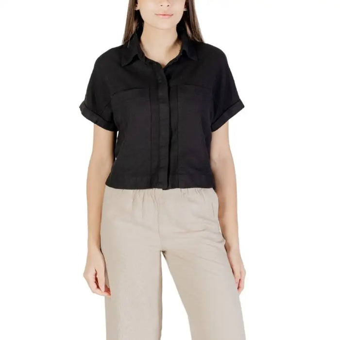 Woman wearing a black short-sleeve button-down shirt and beige pants in the Beige Linen Shirt and Pants Set for Women