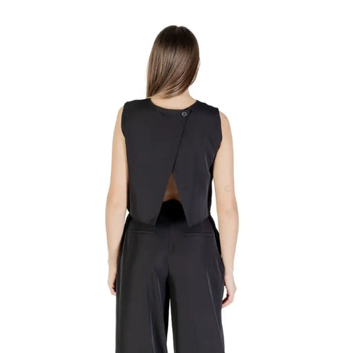 Woman wearing a black sleeveless crop top and matching pants outfit for women
