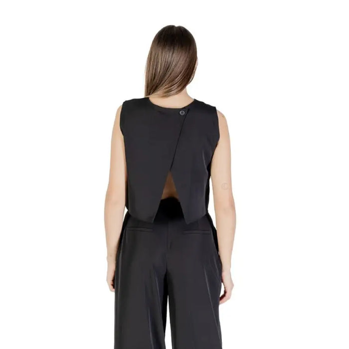 Woman wearing a black sleeveless crop top and matching pants outfit for women