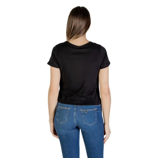 Woman wearing a black knotted T shirt and blue jeans for Women’s Black Knotted T Shirt product