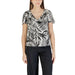 Woman wearing black and white leaf-patterned V-neck top with green shorts