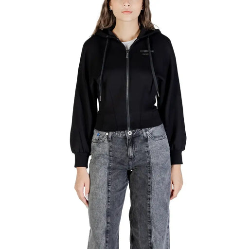 Woman wearing Armani Exchange black zip hoodie with drawstring and acid wash wide-leg jeans