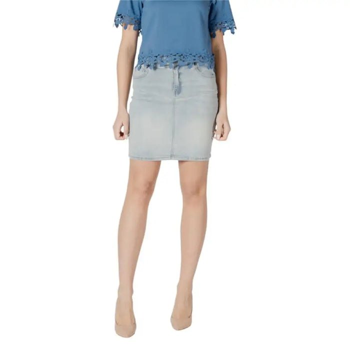 Woman wearing a blue top and denim skirt outfit with heels showcasing style and elegance
