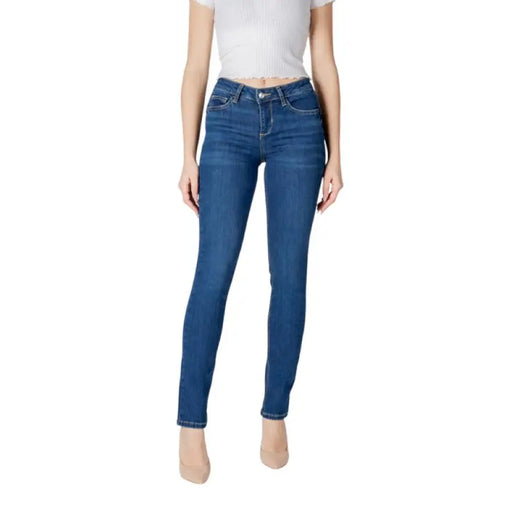 Woman wearing dark wash blue denim skinny jeans showcasing a fashionable fit