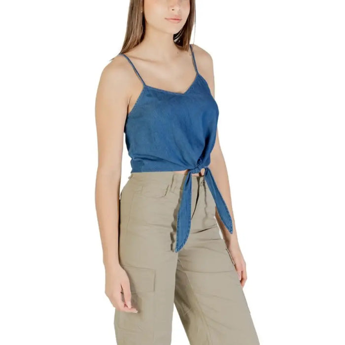 Woman wearing a blue tie-front tank top and khaki cargo pants
