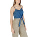 Woman wearing a blue tie-front tank top and khaki cargo pants
