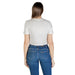 Woman wearing a white layered top and blue jeans for a casual fashion look