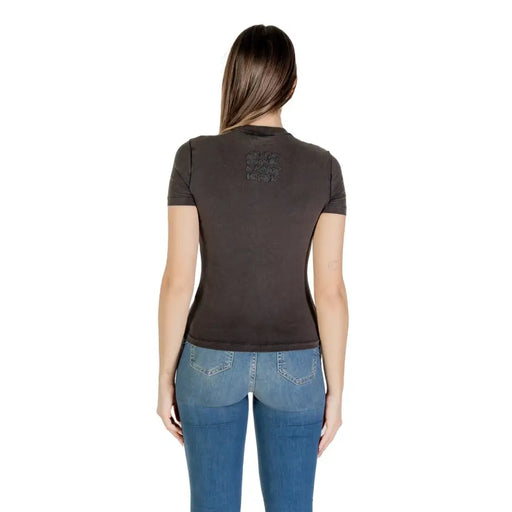 Woman wearing dark grey fitted short-sleeve T-shirt with blue jeans for Desigual Spring Summer collection