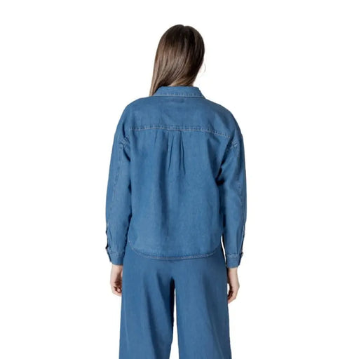 Woman wearing denim button-down shirt and matching pants set showcasing casual style