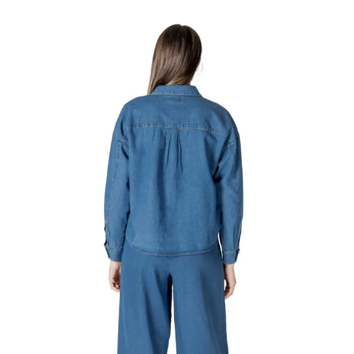 Woman wearing denim button-down shirt and matching pants set showcasing casual style