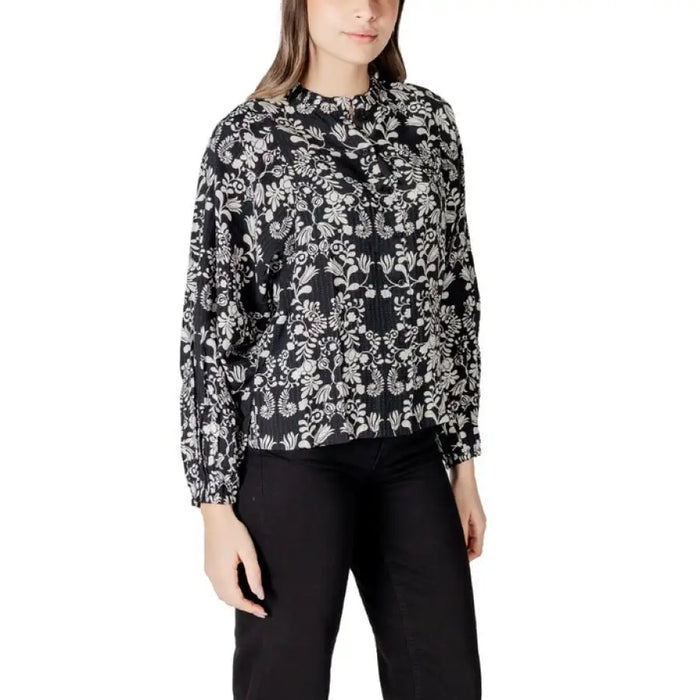 Woman’s black and white floral print blouse shown in product image