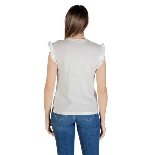 Woman wearing a gray ruffled-sleeve top and blue jeans showcasing a casual outfit