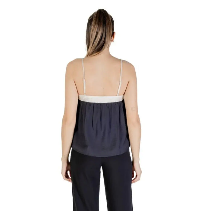 Woman wearing a gray and white camisole top from the Sleeveless Black and Beige Top collection