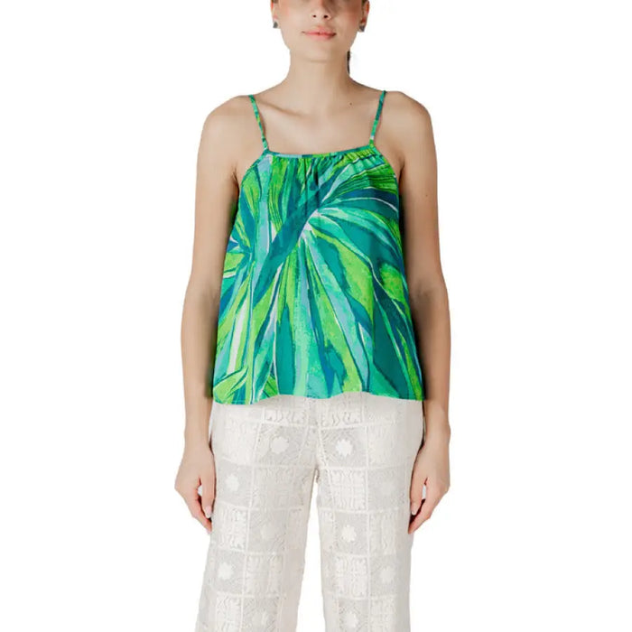Woman wearing a green and white floral patterned camisole top
