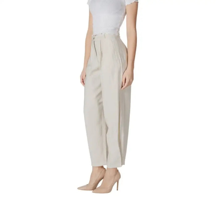 Woman’s high-waisted beige trousers featured in the Beige Pleated Trousers product