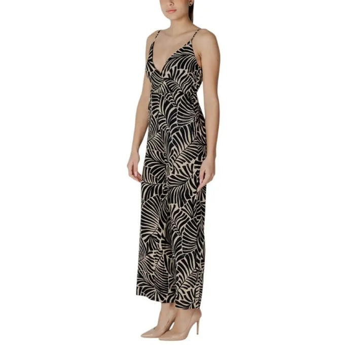 Woman wearing a leaf-patterned sleeveless jumpsuit with spaghetti straps