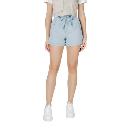 Woman wearing light blue denim paperbag shorts in a fashion product showcase