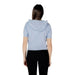 Woman wearing light blue hooded short-sleeve cardigan and black pants displayed