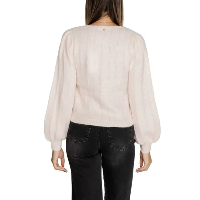 Woman wearing a light pink V neck sweater with balloon sleeves from Women V Neck Sweater collection
