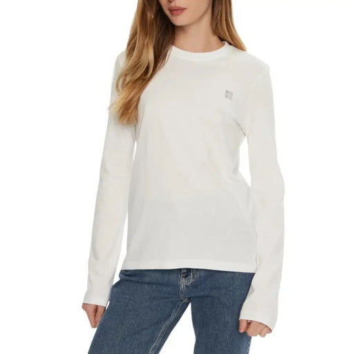 Woman wearing a white long-sleeved shirt as featured in the Black Long Sleeved Shirt product image