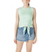 Woman wearing mint green tie-front tank top and denim mini skirt showcasing style