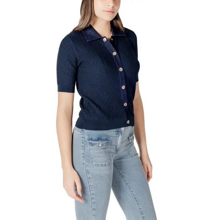 Woman wearing navy knit button-down top and light blue jeans featured in Navy Knit and Polo Tops with Light Blue Jeans