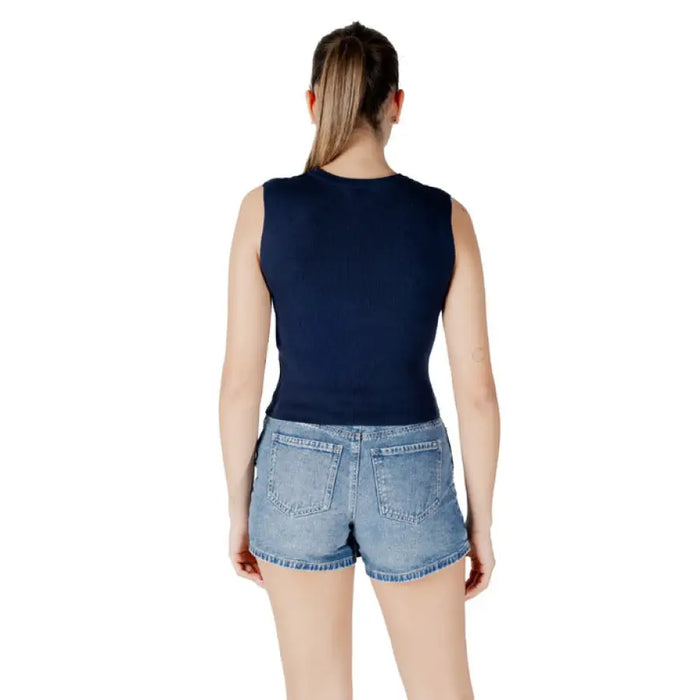 Woman wearing navy tie-front tank top and denim mini skirt, casual summer outfit