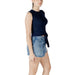 Woman wearing navy tie-front tank top and denim mini skirt for fashion style display