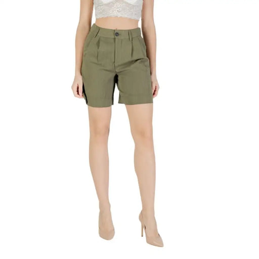 Woman wearing olive green shorts paired with a beige high waisted top