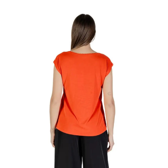Orange V neck top for women styled with black pants