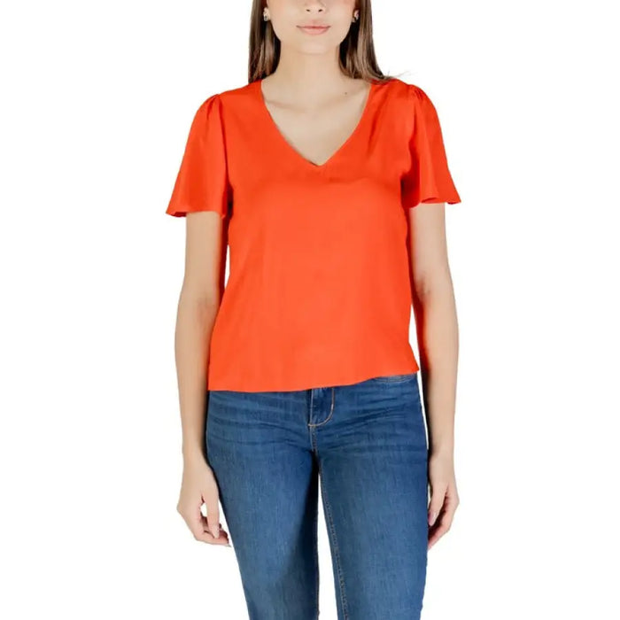Woman wearing an orange V-neck blouse from Womens Black V Neck Flutter Sleeve Top and Green Shorts ensemble